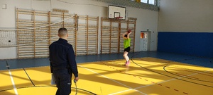 Umundurowany funkcjonariusz policji nadzoruje poprawność przebiegu eliminacji.