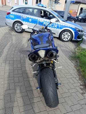 Oznakowany radiowóz wraz z zatrzymanym motocyklem.