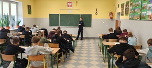 Funkcjonariuszka policji pilnująca porządku podczas testu teoretycznego.