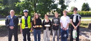Umundurowany policjant wraz z uczniami Szkoły w Rogowie.