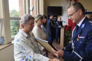 Komendant Powiatowy Policji w Brzezinach wręczający podziękowania dla cywilnych pracowników policji.