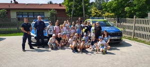 Grupowe zdjęcie półkolonii wraz z policjantami.