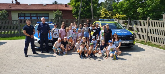 Grupowe zdjęcie półkolonii wraz z policjantami.