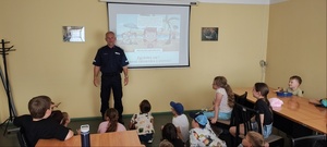 Funkcjonariusz prowadzący zajęcia profilaktyczne dotyczące bezpiecznych wakacji.