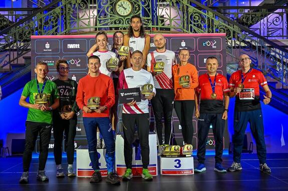 Sierżant sztabowy Bartłomiej Kurdek na drużynowym podium PKO  Wieczornego Półmaratonu.