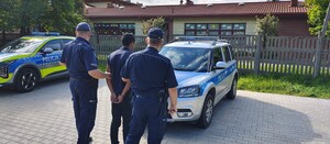 Umundurowani policjanci z osobą zatrzymaną.