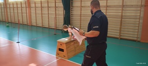 Uczennica pod nadzorem funkcjonariusza policji pokonuje tor przeszkód.